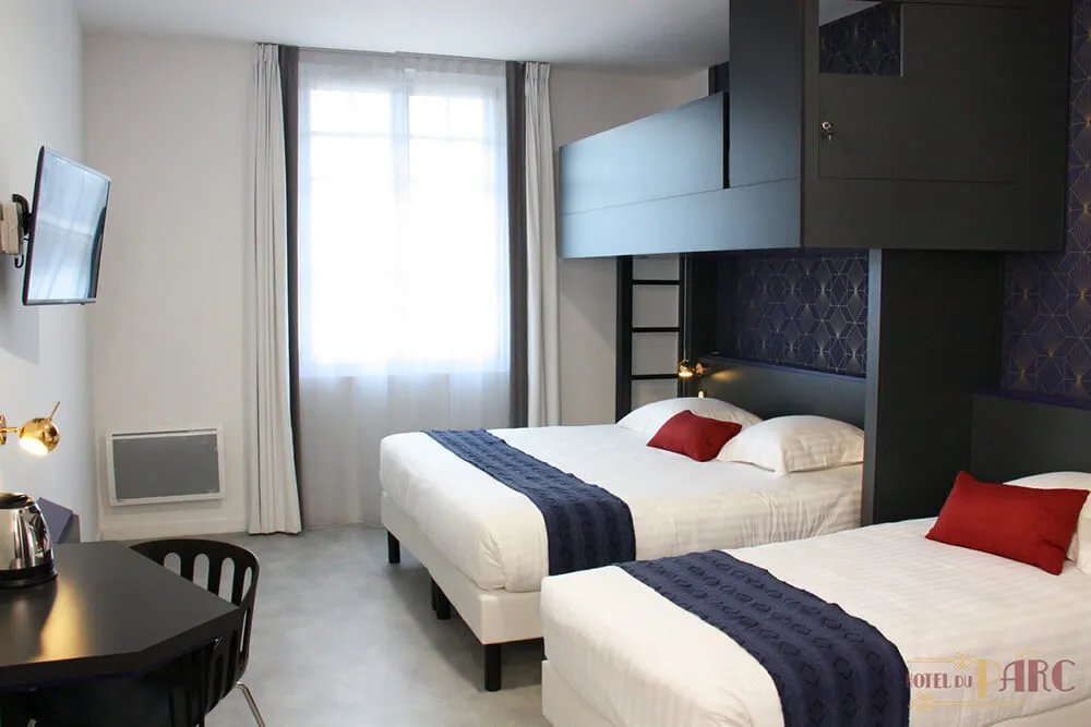 Chambre familiale spacieuse à l’Hôtel du Parc Hossegor, équipée de deux lits jumeaux, d’une mezzanine intégrée, d’un bureau et d’une décoration élégante aux tons bleu nuit et or