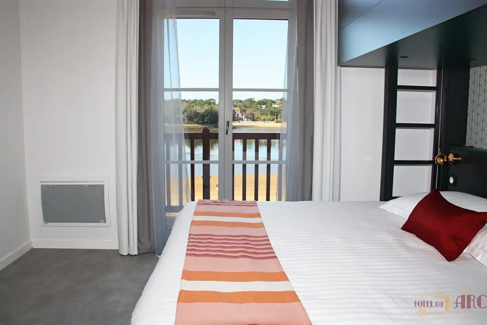 Chambre double à l’Hôtel du Parc Hossegor avec lit confortable, décoration épurée et vue directe sur le lac marin