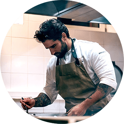 Chef cuisinier concentré en pleine préparation dans la cuisine de l’Hôtel du Parc Azureva