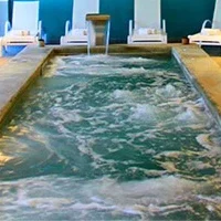 Bassin jacuzzi intérieur avec jets massants et chaises longues