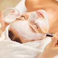 Soin du visage appliqué au pinceau par une esthéticienne